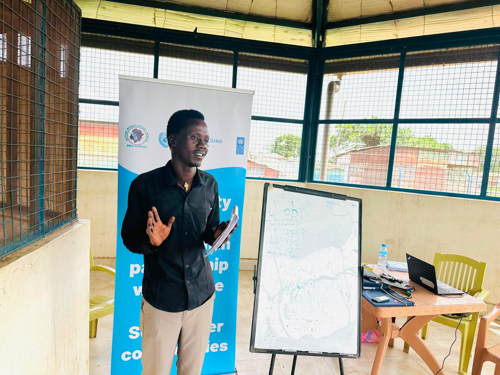 An AWA-AFRICA trainer leading a session at a flipchart